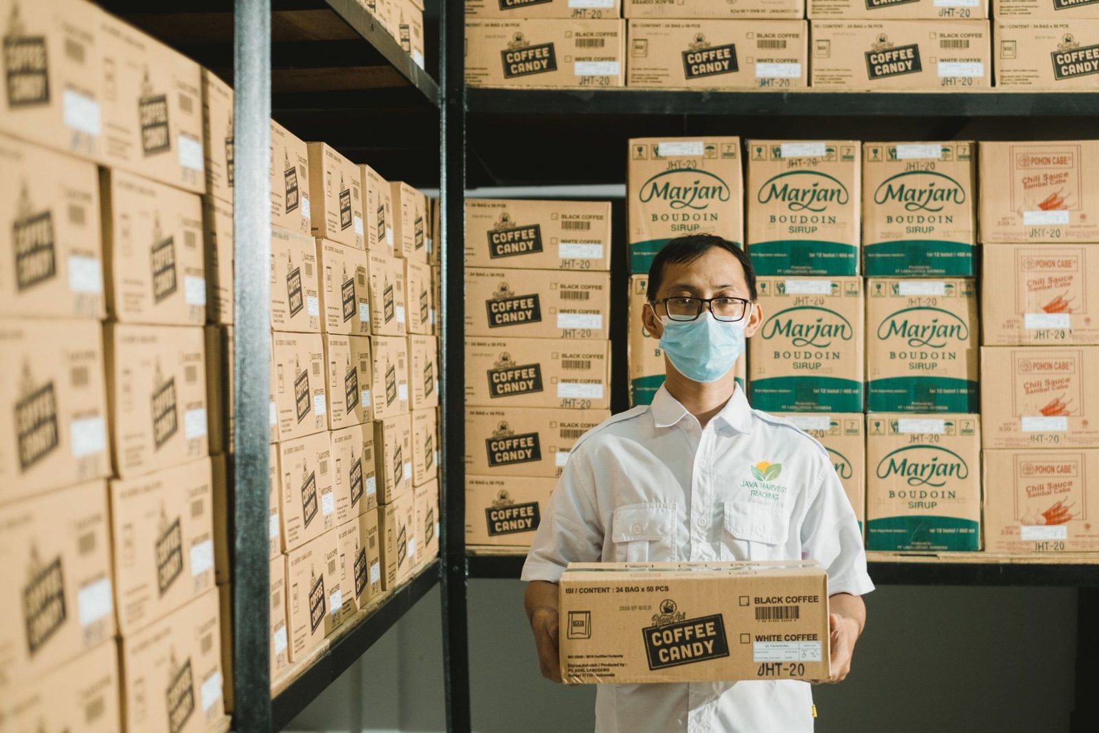 A Java Harvest Trading team member holding a carton in the warehouse